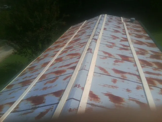 Rusted metal roof panels with new wood purlins before replacement — Storm Damage Roof Repair in Duquesne by Roofing Brothers