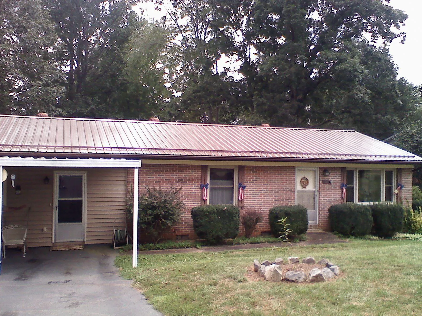 Bronze metal roof and carport on a brick ranch home — Roof Repair work by our crew in Duquesne